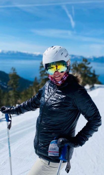 A woman posing for a photo while skiing. She can ski easily becuse she bought a home in Carson City, NV.